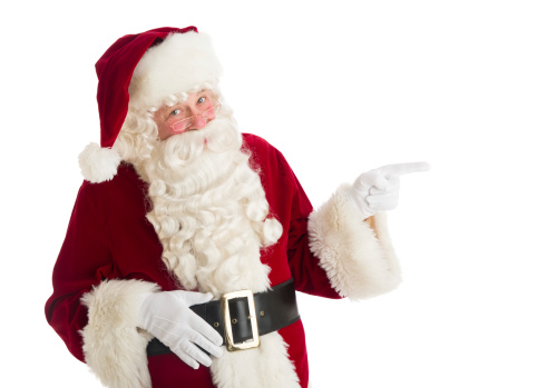 Portrait of Santa Claus pointing towards copy space against over white background