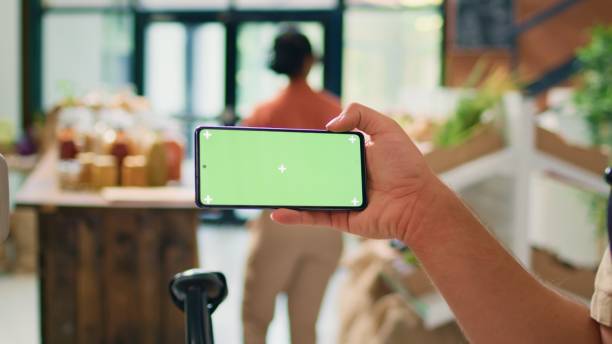 istock Seller showing greenscreen on phone 1765024990
