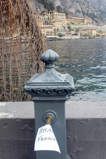 Post (hydrant) on the quay wall at Lake Garda. The note says 