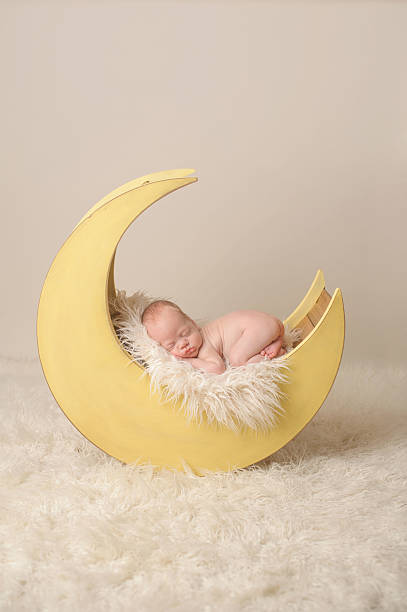 istock Preemie Newborn Boy Sleeping on Wooden Moon Prop 176505256