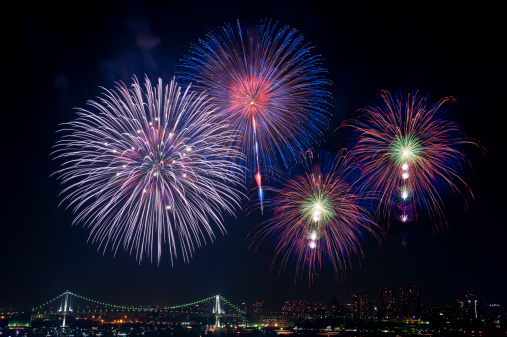 Fireworks held in Tokyo Bay with Rainbow Bridge in the background.