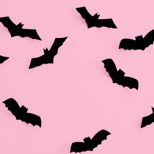 istock Halloween concept. Black paper bats on a pink background. Copy space 1765079301