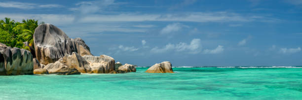 turquoise water and granite rocks, panorama of  anse source d'argent beach, la digue island, seychelles web banner - flag of seychelles imagens e fotografias de stock