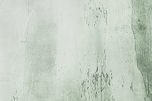 Gray green textured concrete background with light base darker in the recesses. Abstract texture for graphic design or wallpaper, top view.