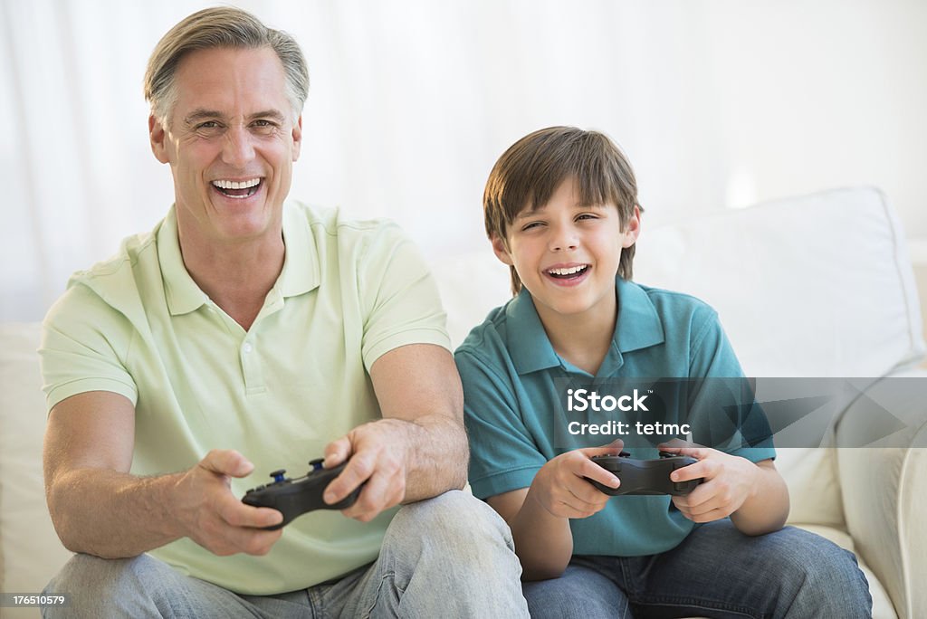 Padre giocando un Video gioco insieme a casa - Foto stock royalty-free di Console - Attrezzatura elettronica