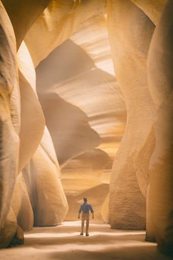 A miniature man walks through a miniature slot canyon, similar to Antelope Canyon in Arizoina.