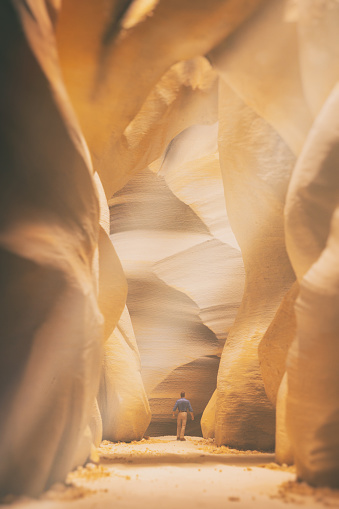 A miniature man walks through a miniature slot canyon, similar to Antelope Canyon in Arizoina.