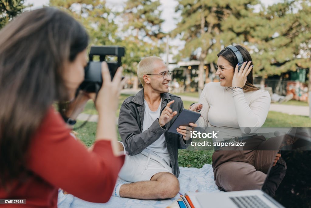 This is my fav tune Group of students having a break from studying in the park 20-24 Years Stock Photo