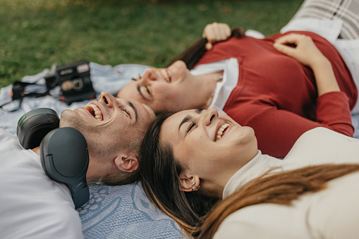 Group of male and female students lying in the park and smiling