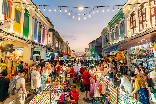 PHUKET, THAILAND - April 24, 2023: Tourists are walking on the Phuket Walking Street is a night market that takes over the beautiful Thalang Road in Phuket Old Town every Sunday evening
