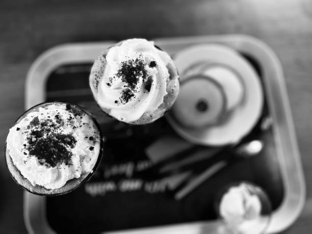 Directly above whipped cream topping and cherry Bakewell cakes on a tray