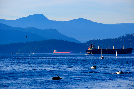 Vancouver British Columbia in Canada with mountains in background and tankers and boats in ocean water