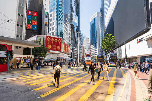 Hong Kong - February 28, 2023: Crowd of people crossing the road during rush hour at Central District in Hong Kong