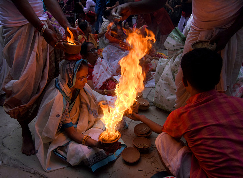 Dhuno pora ritual performed during Durgastami (the 8th day of Durga puja) by the married women of 'Bonedi bari' (rich families of businessmen). In this ritual three clay pots with burning hay are balanced on their head and hands. Then a fire show was created by throwing powdered 'dhuno' or frankincense into the pot. These pictures show the preparation and the actual performance of 'dhuno pora'. These pictures are precious as this ritual is almost dying with time and only performed by selected families.