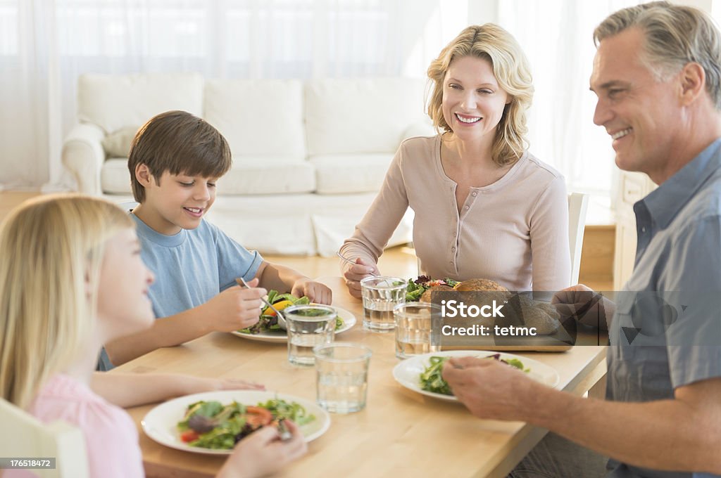 Родители и дети, имеющие еды вместе на обеденный стол - Стоковые фото 10-11 лет роялти-фри