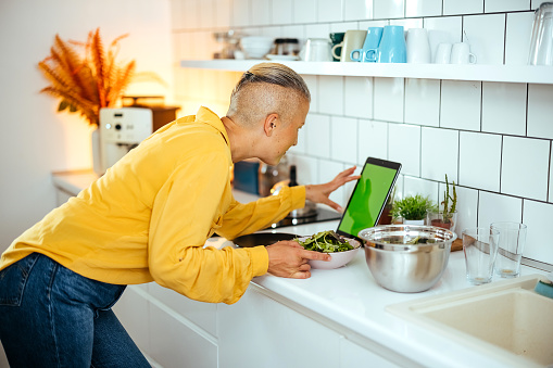 Woman uses a digital tablet in the kitchen