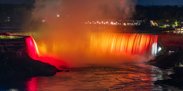 Orange illuminated Horseshoe falls at night, Niagara Falls, Canada