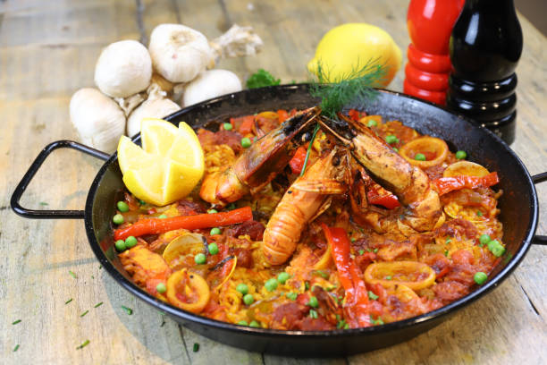 Spanish dish Paella with seafood in soft tomato and white wine sauce stock photo