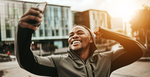 Happy black man, city and selfie for fitness or photography after running, training or exercise. Active African male person smile and flexing for sports photograph, picture or memory in an urban town