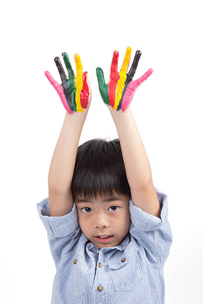 Asiático rapaz engraçado, levantar as mãos para o céu colorido - fotografia de stock