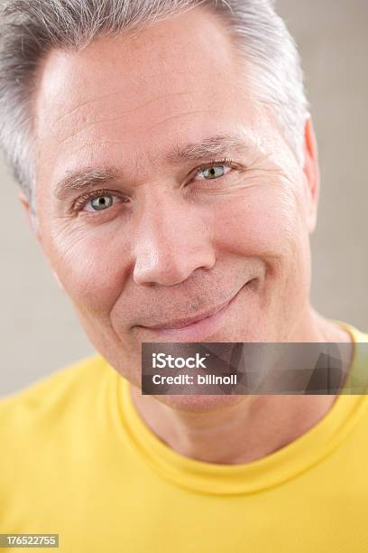 Sonriendo De Edad Intermedia Hombre Con Pelo Gris Foto de stock y más banco de imágenes de Amarillo - Color - Amarillo - Color, Camiseta, Hombres