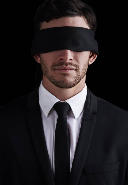 istock Dark, vision and a business man in a blindfold on a black background for control or censorship. Oppression, lost and blinded with a young corporate employee unaware of future issues as a professional 1765229511