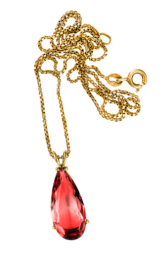 Gold necklace with large red crystal pendant isolated over white