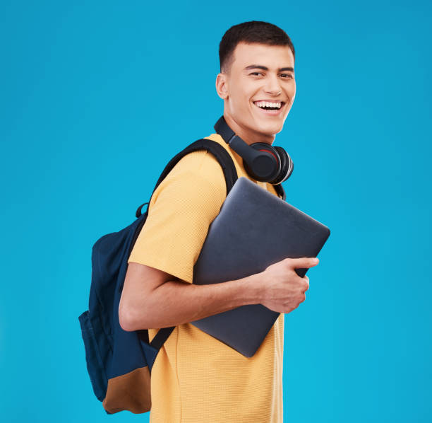 istock Man, smile and laptop for education, student and portrait in studio by blue background, study and tech. Happy asian model, scholarship and online learning at university, registration and college 1765239001