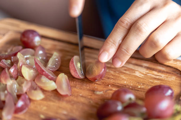 istock A woman cuts grapes on a cutting board. 1765240759