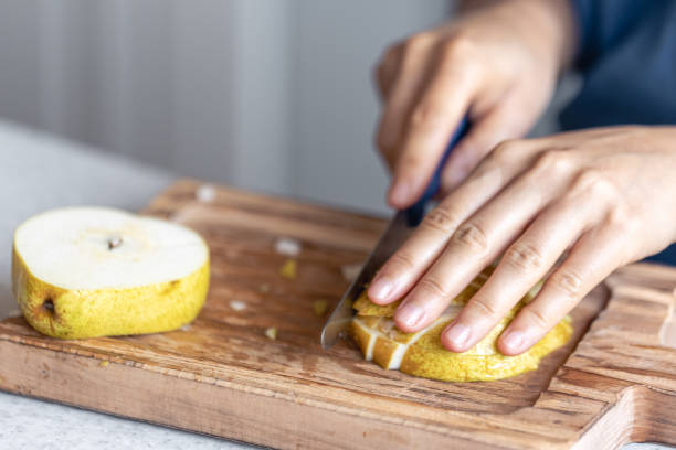 istock A woman cuts a pear into small pieces, close-up. 1765240781
