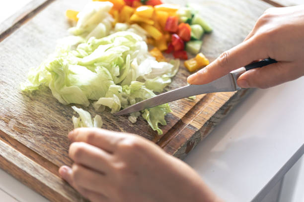 istock A woman cuts vegetables on a cutting board. 1765241363