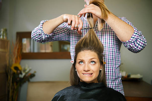 Nervous brunette woman getting haircut at a salon female client in hairdresser shop uncertain about cutting hair and biting lips cutting hair stock pictures, royalty-free photos & images