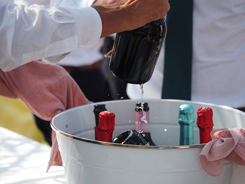 catering staff serving cold white sparkling wine prosecco to event participants in private event outdoors