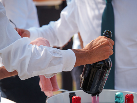 catering staff serving cold white sparkling wine prosecco to event participants in private event outdoors