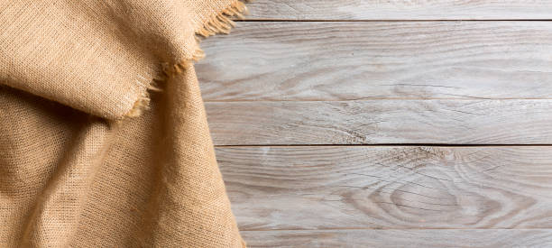 istock Burlap hessian sacking cloth on wooden table background with free space. 1765273411