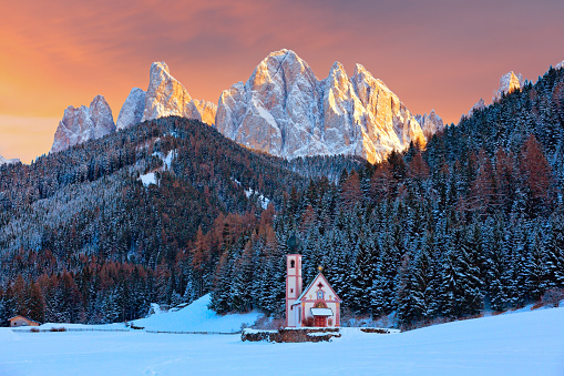 Winter view of the church of St. Johann in Ranui with Puez-Odle Dolomites, Villnoss Val di Funes, South Tyrol, Italy