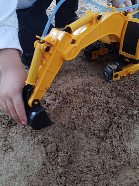 istock Boy playing with an excavator in the sand in a park. 1765279028