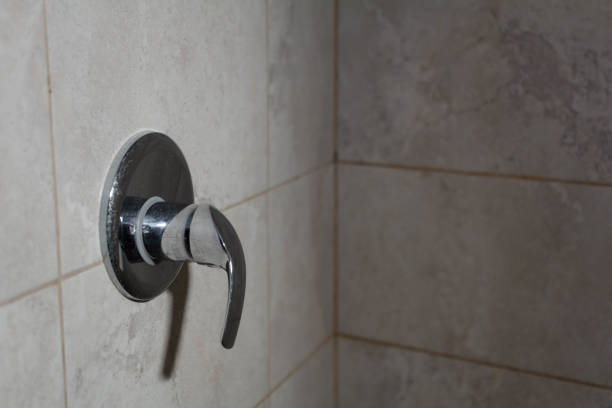 Modern faucet close up. Batroom interior with sink, water tap and green, colorful tiles.
