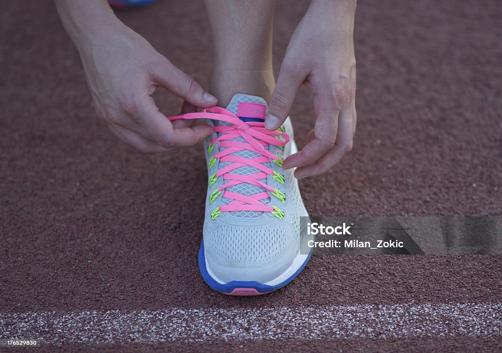 Runner at the start. Athletic teenage girl in start position on track . Active Lifestyle Stock Photo