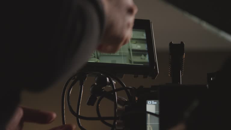 Videographer Adjusting External Screen on Camera before Filming in Studio