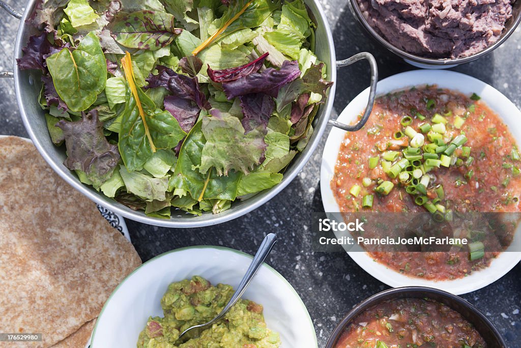 Vegana mexicana-Tortillas, Salsa picante estilo Cajun, frijoles refritos, Guacomole & ensalada - Foto de stock de Acelga libre de derechos