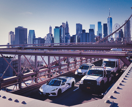 Traffic jam on the Brooklyn Bridge during peak traffic time with a view of Manhattan skyline in the background.