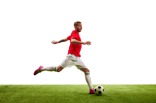 Full length portrait of professional soccer player contemplating perfect kicking of ball. Footballer's focus, unwavering and determined. Concept of game, sport, recreation, active lifestyle.