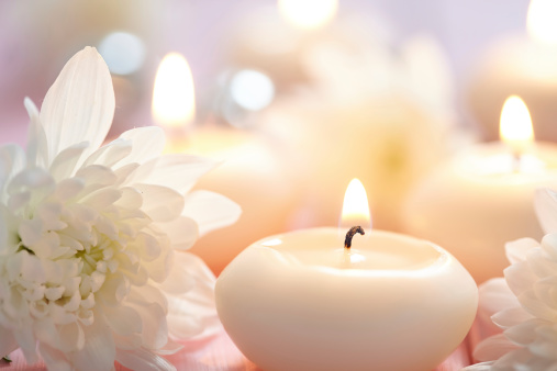 Soothing photo of white candles and white flowers.