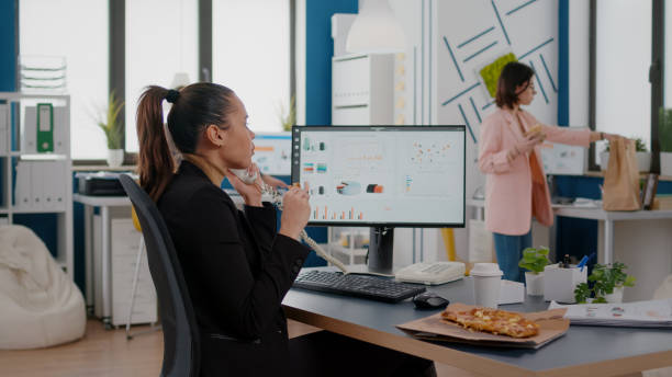 istock Multitasking businesswoman talking at landline explaining company graphs to remote collegue 1765351254