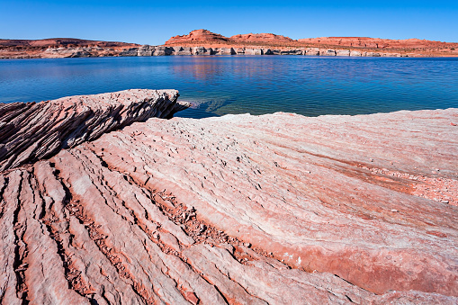 Grandiose huge lake of artificial origin among the picturesque red sandstone cliffs. The coast is cut by narrow canyons. Lake Powell. USA.