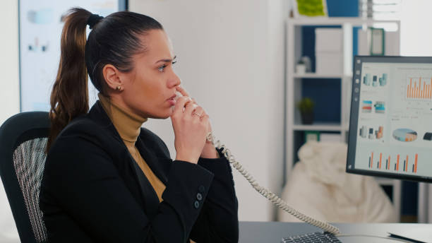 istock Multitasking executive manager talking at landline explaining company graphs to remote collegue 1765351275
