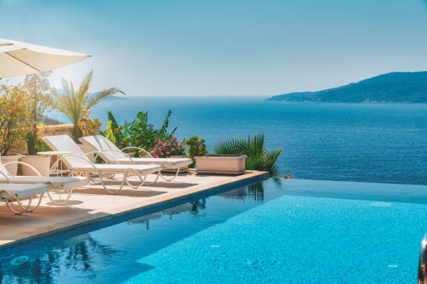 veranda mit liegestühlen und sonnenschirm mit meerblick - luxusbad stock-fotos und bilder