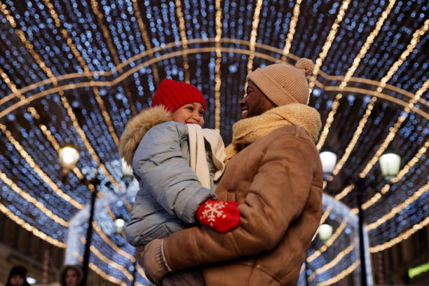 istock Black father and daughter embracing outdoors with lights 1765380103