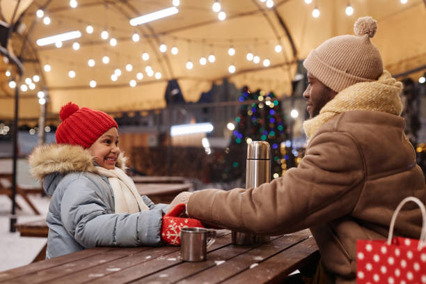 istock Father and daughter enjoying hot drinks outdoors in winter 1765380701